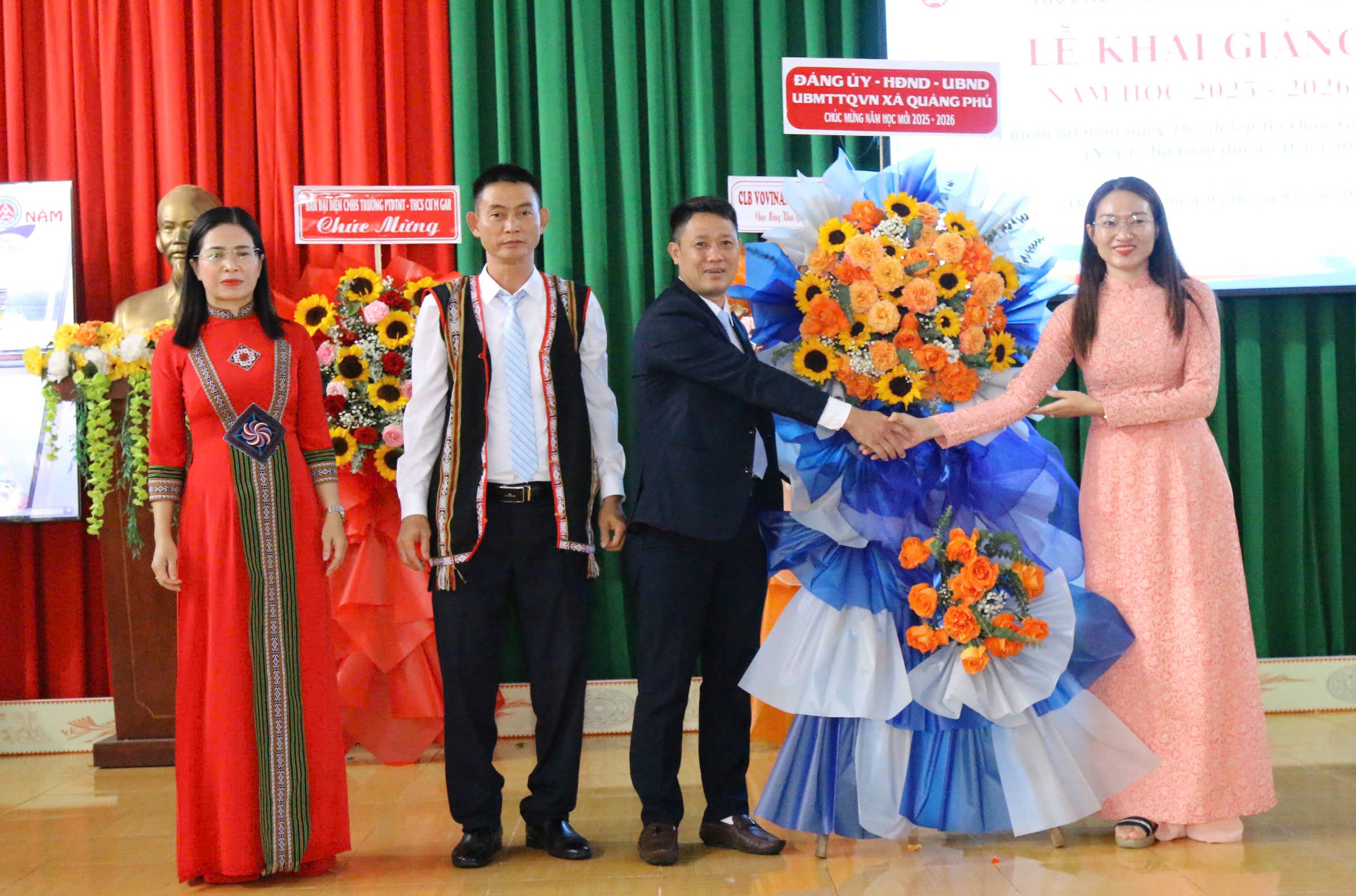 Đồng chí Nay Hlan - Phó Bí thư Đảng ủy, Chủ tịch HĐND xã tặng hoa chúc mừng trường PT DTNT THCS Cư Mgar